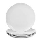 A stack of white opal glass dinner plates with a glossy finish, with one plate standing upright on top of the others, set against a plain white background.