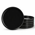 A set of glossy black round opal glass dinner plates, with one standing upright in front of a stack of five on a clean white background.